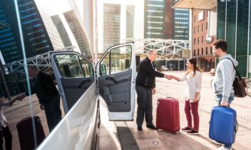 Driver,of,a,airport,shuttle,minivan,,greeting,his,passengers,with